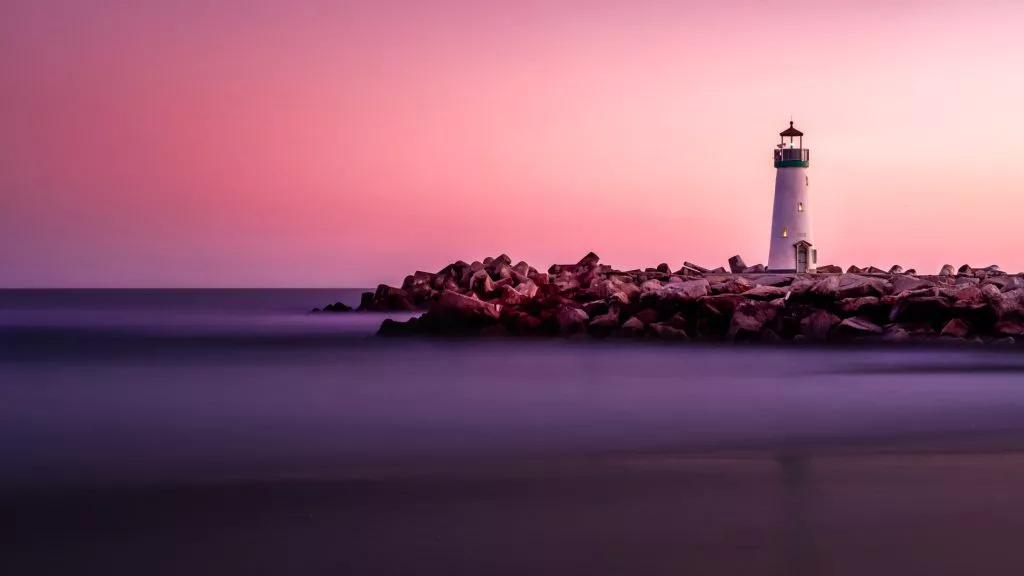 Lighthouse and rocks at dusk